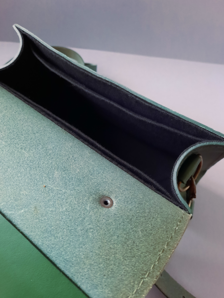 Intérieur du sac bandoulière en cuir vert, compartiment principal