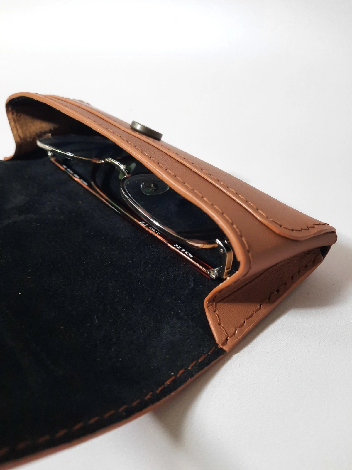Étui à lunettes en cuir taurillon marron ouvert avec lunettes à l'intérieur